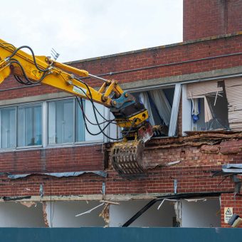 demolition-excavator-arm-tearing-down-brick-buildi-2026-09-22-21-47-49-utc